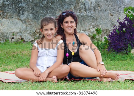 Beautiful latin mother and daughter in a park during summer