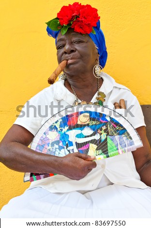 HAVANA-JUNE 29:Old black lady with a fine cigar June 29, 2011 in Havana. The african culture and religions have a huge influence in Cuba where approximately 50% of the population is of african descent