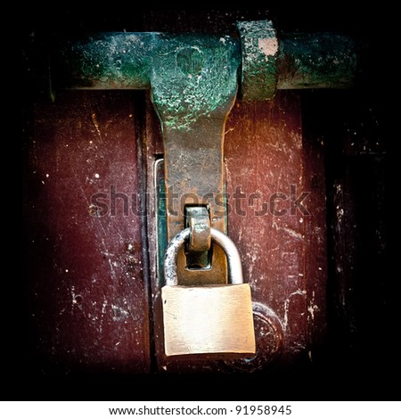 Bronze padlock in an old grunge wooden door