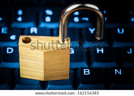 Open padlock on a glowing blue computer keyboard useful to illustrate data security