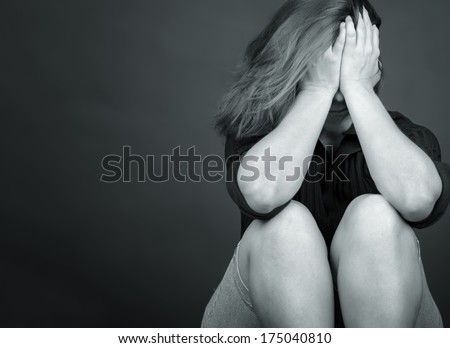 Black and white emotional image of a sad and lonely woman crying (with space for text)