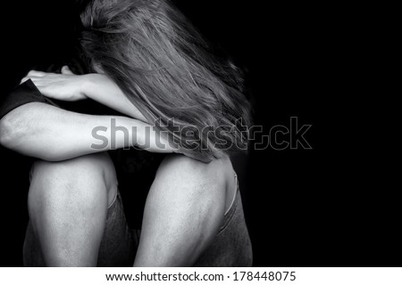 Black and white image of a young woman crying useful to illustrate stress, depression or domestic violence