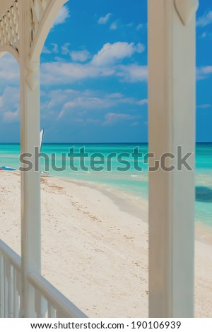 View of Varadero beach in Cuba framed by the columns of a beautiful wooden terrace (focused on the beach)