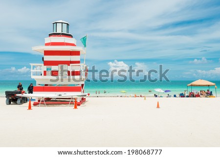 MIAMI,USA - MAY 31,2014 : People enjoying the beach next to a colorful lifeguard tower in Miami Beach