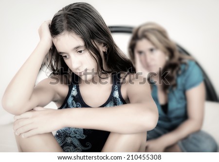 Teenager conflict - Sad teenage girl with her worried mother on the background