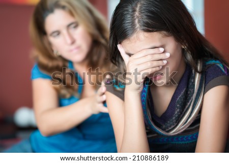 Teenager problems - Mother comforts her troubled teenage daughter who cries