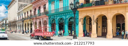 HAVANA,CUBA - MARCH 17, 2014 : Street scene with people, old cars and colorful buildings in Old Havana
