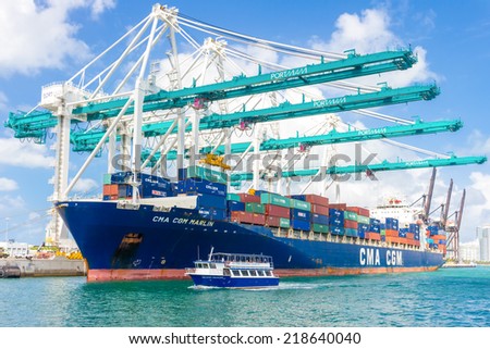 MIAMI,USA - AUGUST 26, 2014 : Ship with containers unloading cargo at the Port of Miami assited by big modern cranes