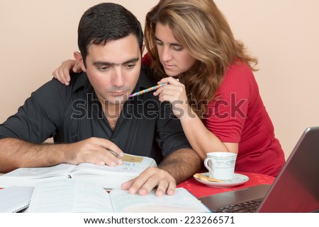 Adult education - Hispanic man and woman studying or doing office work at home