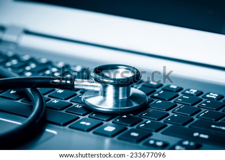 Computer or data analysis - Stethoscope over a laptop computer keyboard toned in blue