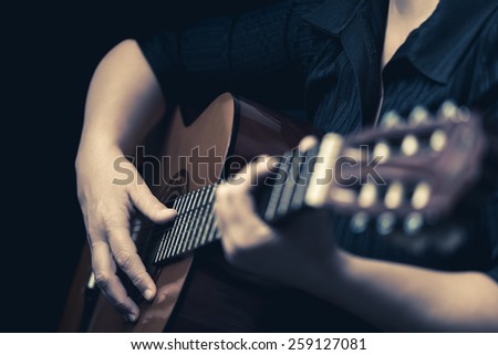 Classic guitar - Vintage toned image of musician hands playing an acoustic guitar