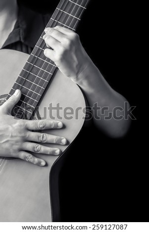 Acoustic guitar - Musician hands playing a classic guitar isolated on a black background