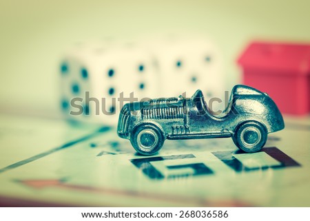 LONDON,UK - APRIL 1,2015 : Car token and dice on a vintage monopoly game board
