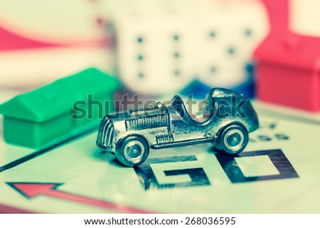 LONDON,UK - APRIL 1,2015 : Car token and dice on a vintage monopoly game board