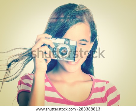 Instagram toned image of a teenage girl using a vintage camera