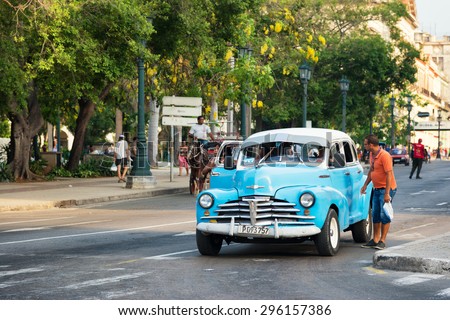 HAVANA,CUBA - JUNE 28, 2015 : A man asks for a ride in an old american car still used as a taxi in Old Havana