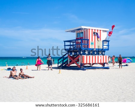 MIAMI,USA - AUGUST 8,2015: Summer day at South Beach in Miami next to the famous lifeguard tower decorated with the colors of the american flag
