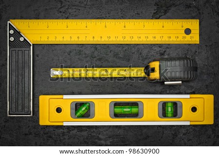 Set of measuring tools on a textured black metallic background