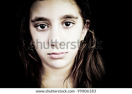 Dramatic portrait of a very sad girl crying isolated on black with space for text