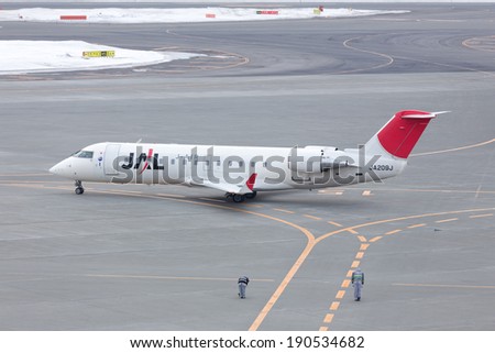 HOKKAIDO, JAPAN - MARCH 18, 2014: JAL Express Bombardier Jet CRJ-200LR at New Chitose Airport, Japan. The Officials Bow for salute to the pilots and passengers which is tradition of Japanese.