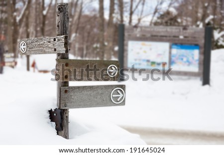 wooden direction sign on the snow