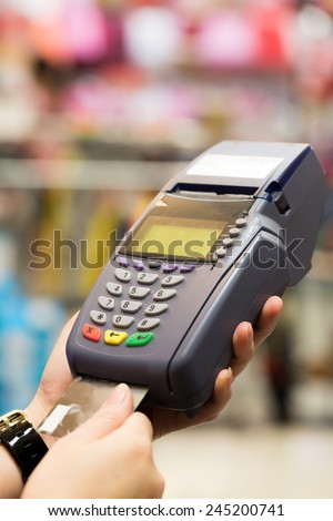 Woman hand with credit card swipe through terminal for sale in store