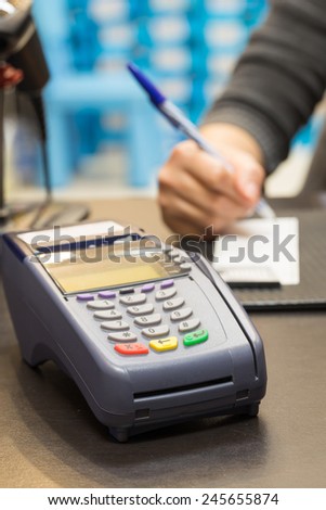 Credit Card Machine With Consumer Signing Transaction In Background
