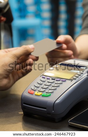 Credit Card Machine On The Table with Hand Paying by Credit Card