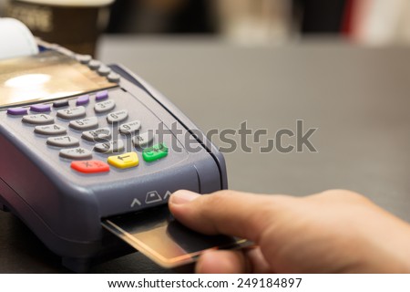 Credit Card Machind with Hand Swipe Credit Card Through Terminal For Sale In Store : Selective Focus