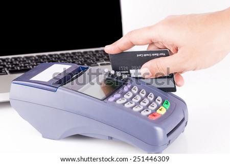 hand holding a credit card with credit card machine