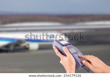 hand with credit card swipe through terminal for sale airplane ticket