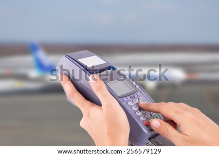 hand with credit card swipe through terminal for sale airplane ticket