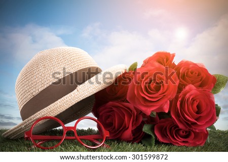 red roses and glasses on green grass with blue sky