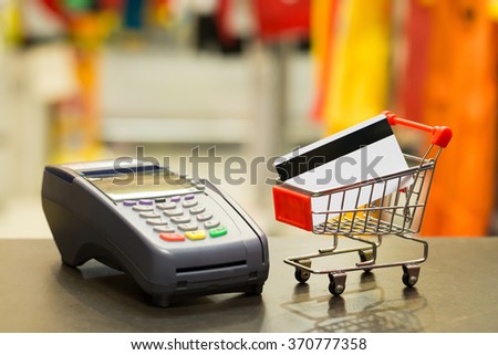 Credit Card In Shopping Cart With Credit Card Machine In Store : Selective Focus On Credit Card