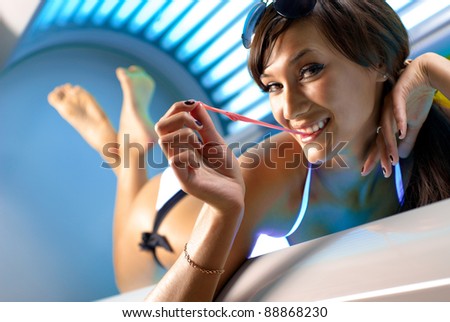 Young attractive brunette girl chewing gum in the solarium
