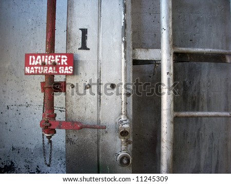 A shot of a red natural gas pipe on a steel wall