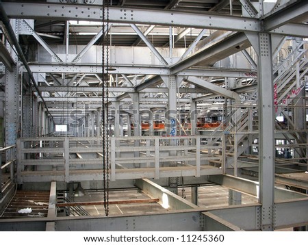 An indoor shot of an abandoned factory made with silver painted steel i-beams.