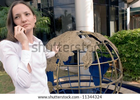 Woman in business attire on her cell phone outdoors