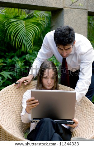 Vertically framed shot of Man and woman in business attire working together outdoors