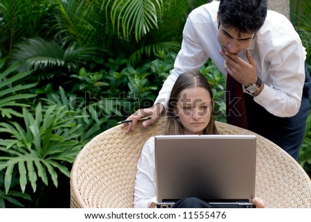 Man and woman in business attire working together outdoors