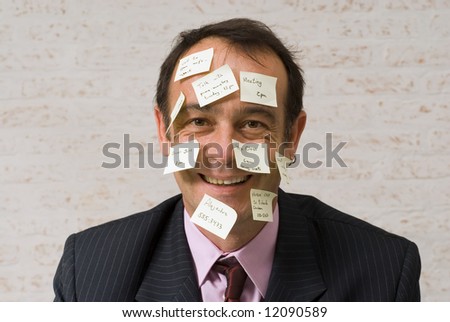 A shot of a business man\'s head covered in yellow sticky-notes.