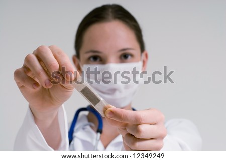 An isolated head shot of a doctor/nurse holding out a bandage, as if to put it on patient.