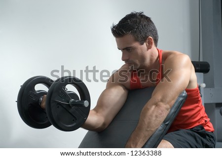An isolated shot of male athlete curling a dumbbell, with his right arm.