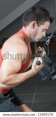 A side-shot of a male weightlifter doing pull-downs.