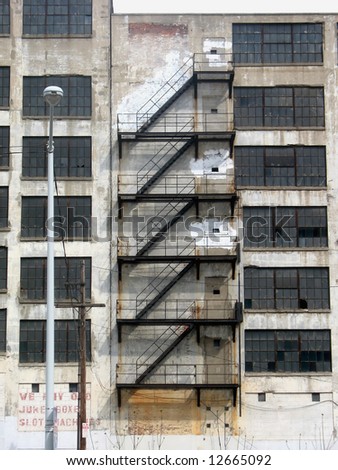 Fire escape stairs snaking down the outside of an old abandoned building