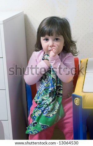 stock photo Adorable little girl clutching her blankie and sucking her 