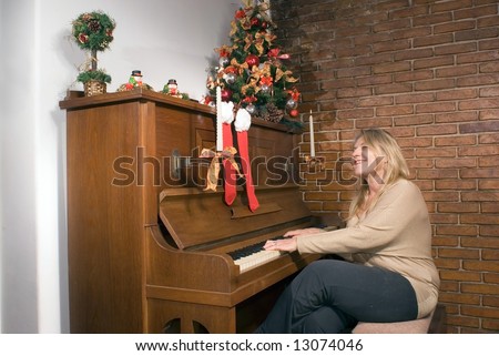 Woman playing the piano at Christmas time. Horizontally framed shot.