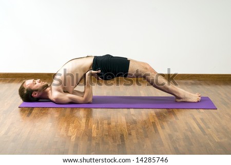 A man, on a purple foam mat, arching his back, stretching. - horizontally framed