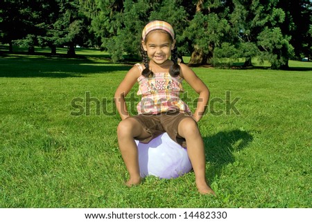 Happy little girl on a bouncy ball - Horizontally framed photograph.