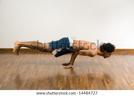 Man Balancing on his hands with his body horizontally in the air. Horizontally framed photograph